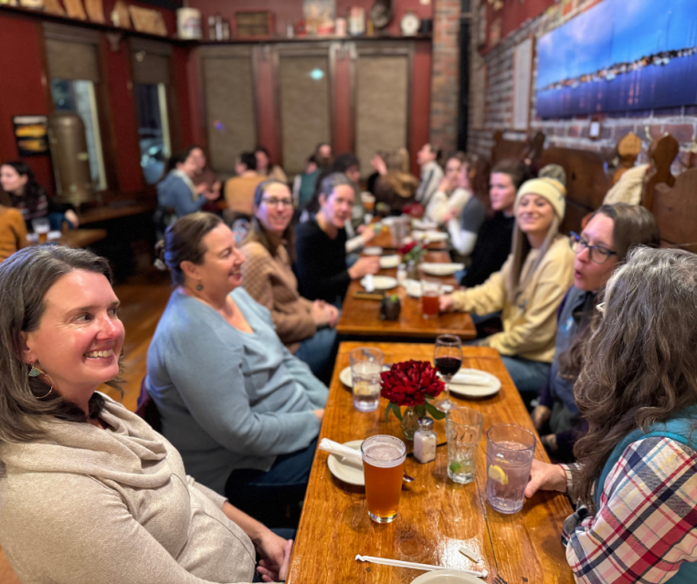 A large group inside a restaurant smiling and laughing