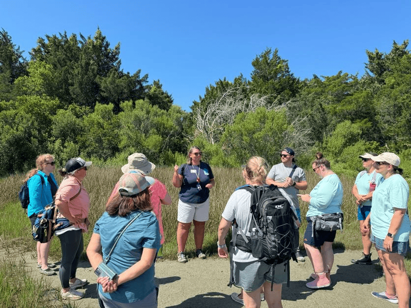 Group of people standing in a circle in the marsh