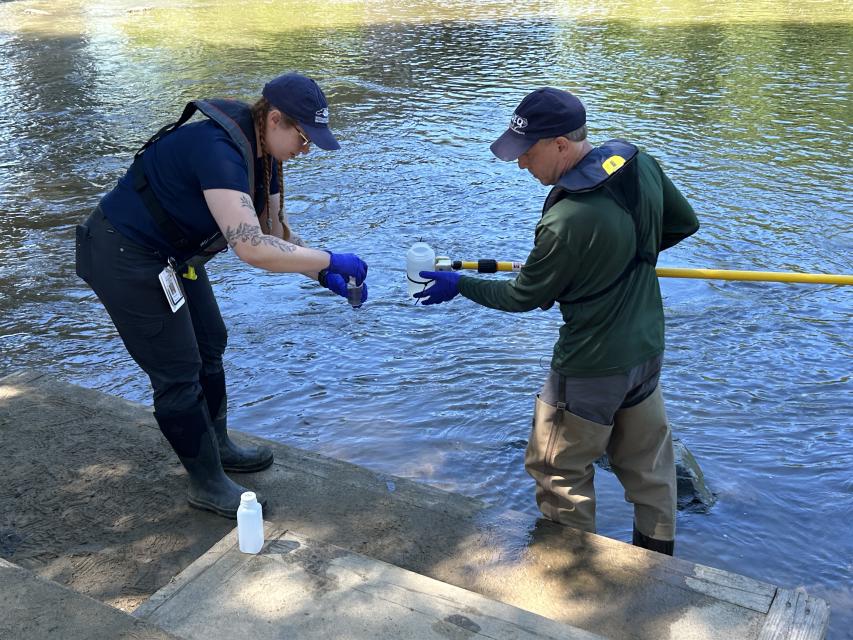 DEQ Secretary Reid Wilson and DWR staff member Rachel Rose take water samples from the French Broad River in Asheville