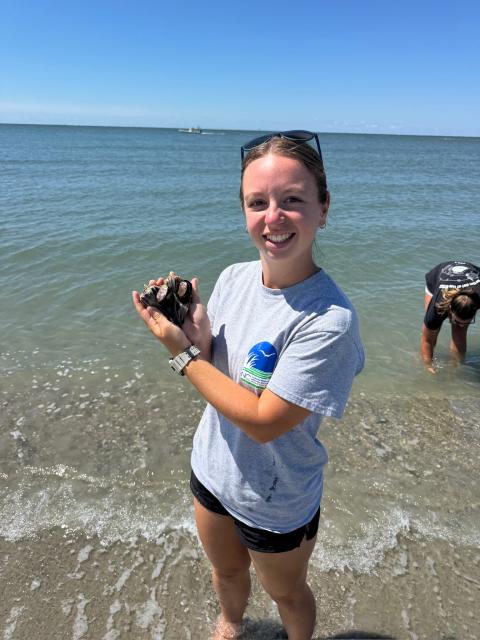 Person holding something from the ocean and smiling