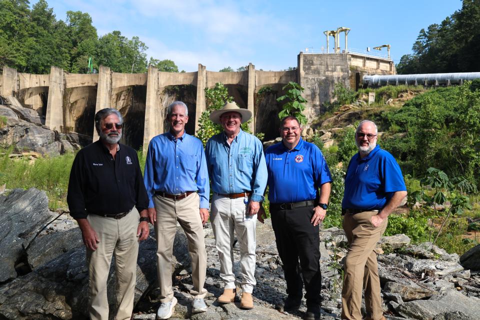 From left: Polk County Commission Chairman Myron Yoder, DEQ Secretary Reid Wilson, DEMLR Director Toby Vinson, Polk County Emergency Management Director Bobby Arledge and Polk County Manager Marche Pittman pose in front of the Turner Shoals Dam, which received $1.3 million to repair damage from Hurricane Helene