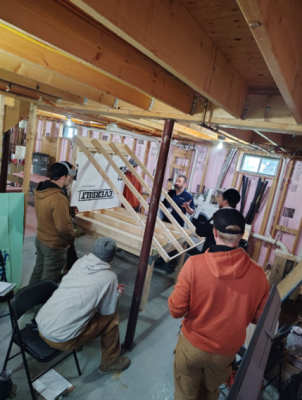 Technicians learning kneewall best practices in weatherization