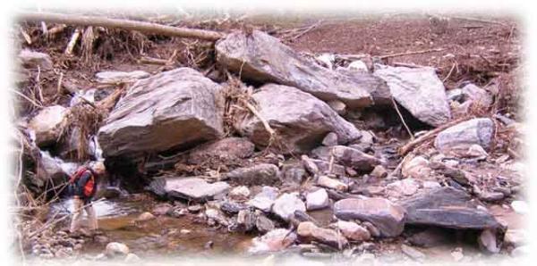 Landslide in Peeks Creek community with large boulders and large debris flow