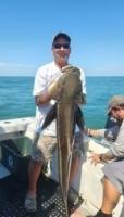 Man on a boat holds up a Cobia 