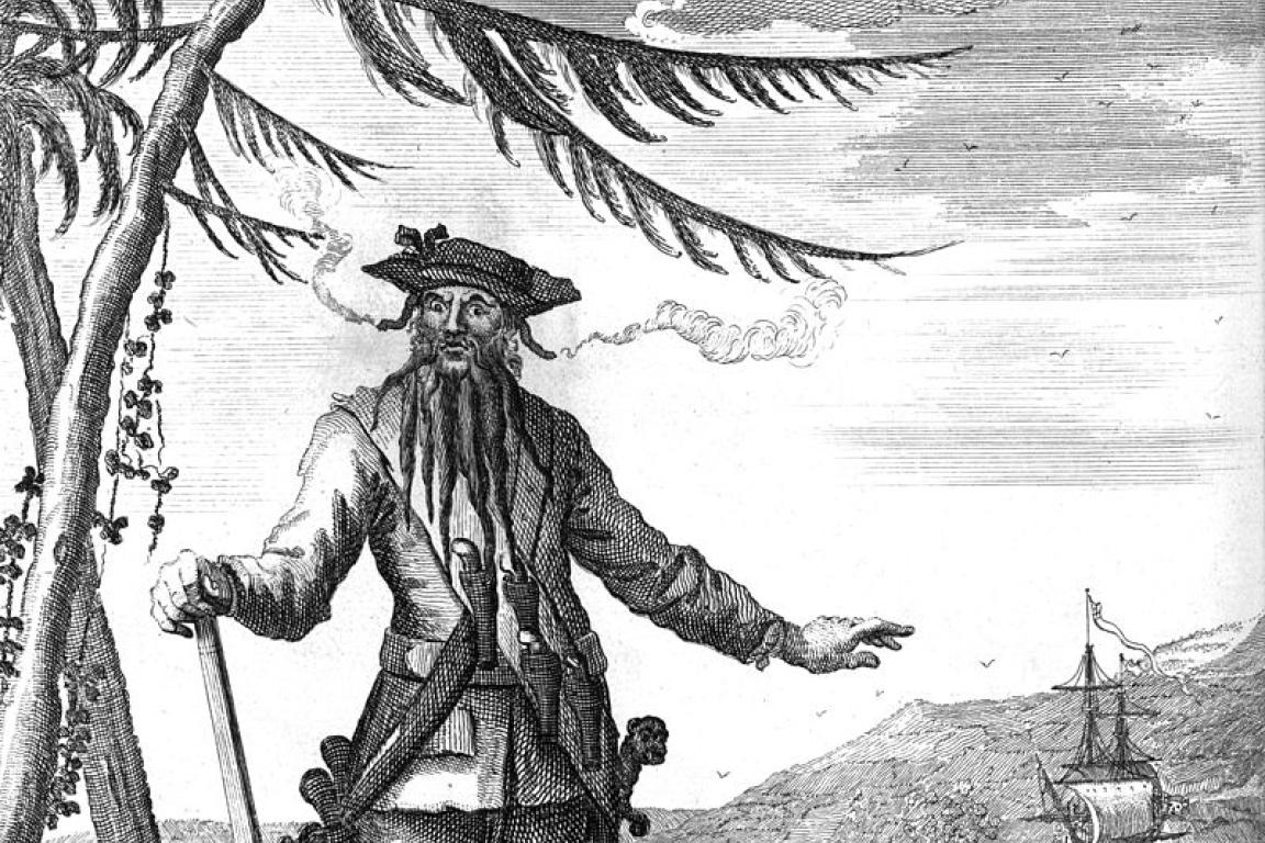 Edward Teach aka blackbeard standing with a cane smoking a pipe