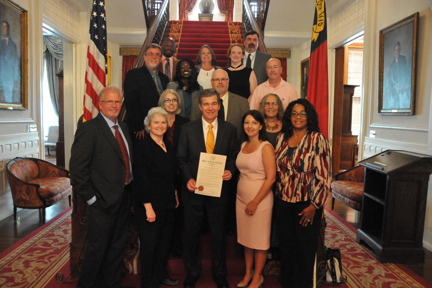 Governor Roy Cooper, surrounded by advocates