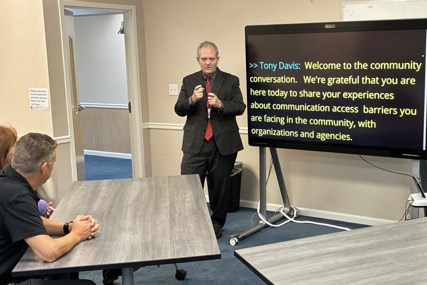 Tony Davis communicates with attendees at a community conversation event.