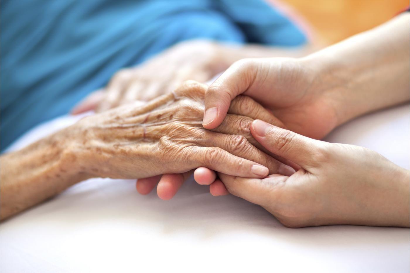 Someone holding an older person's hand. 