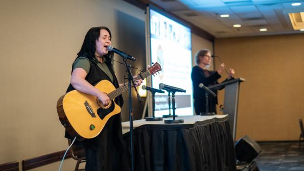 Someone playing the guitar at the ADA event.