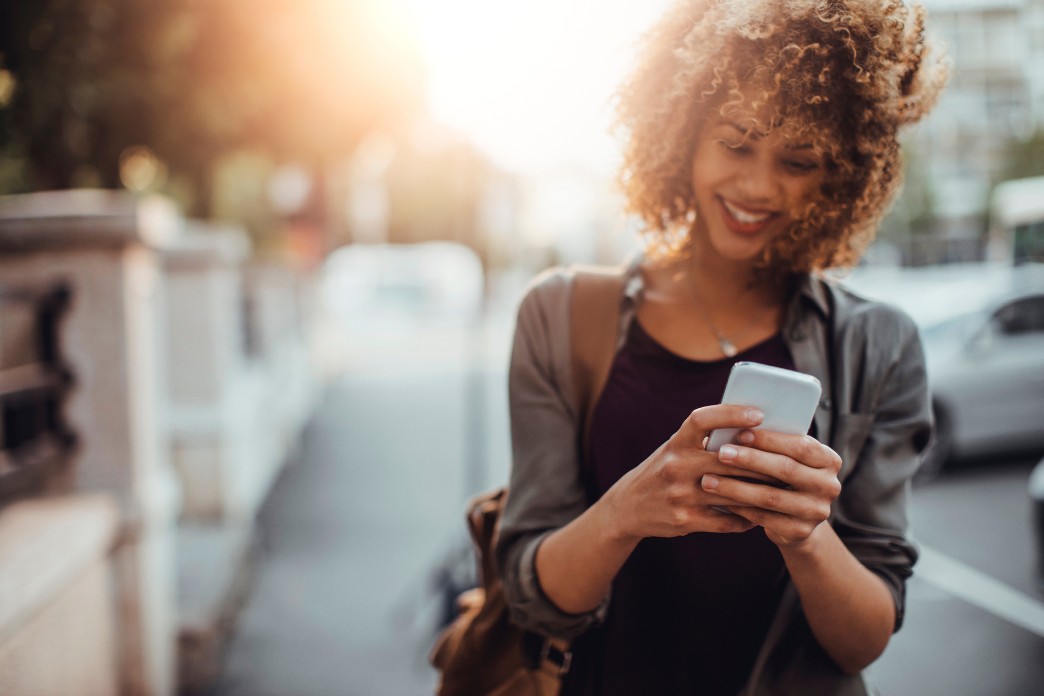 A woman uses a mobile phone on an urban street