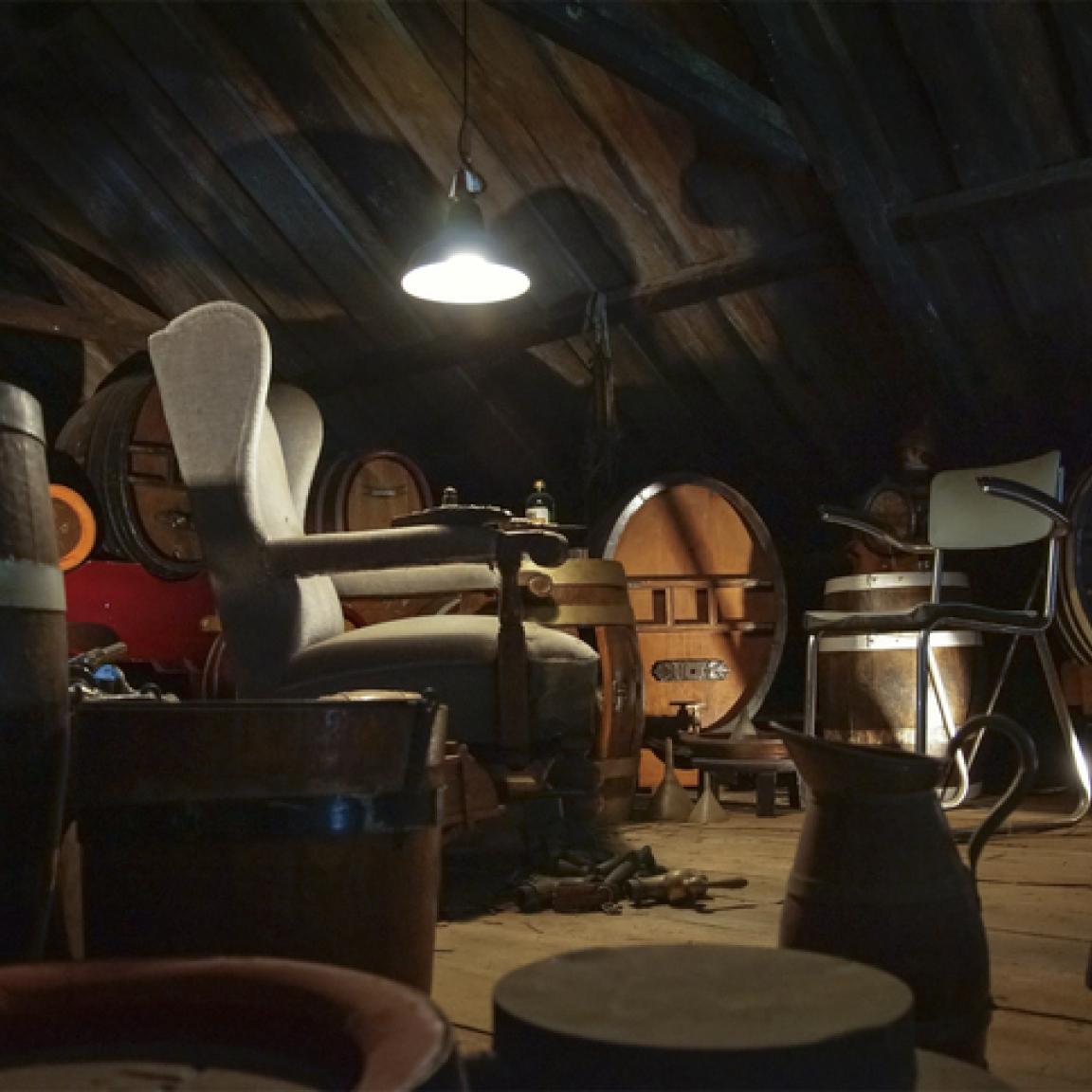 A dusty attic filled with old furniture illuminated by a single light.