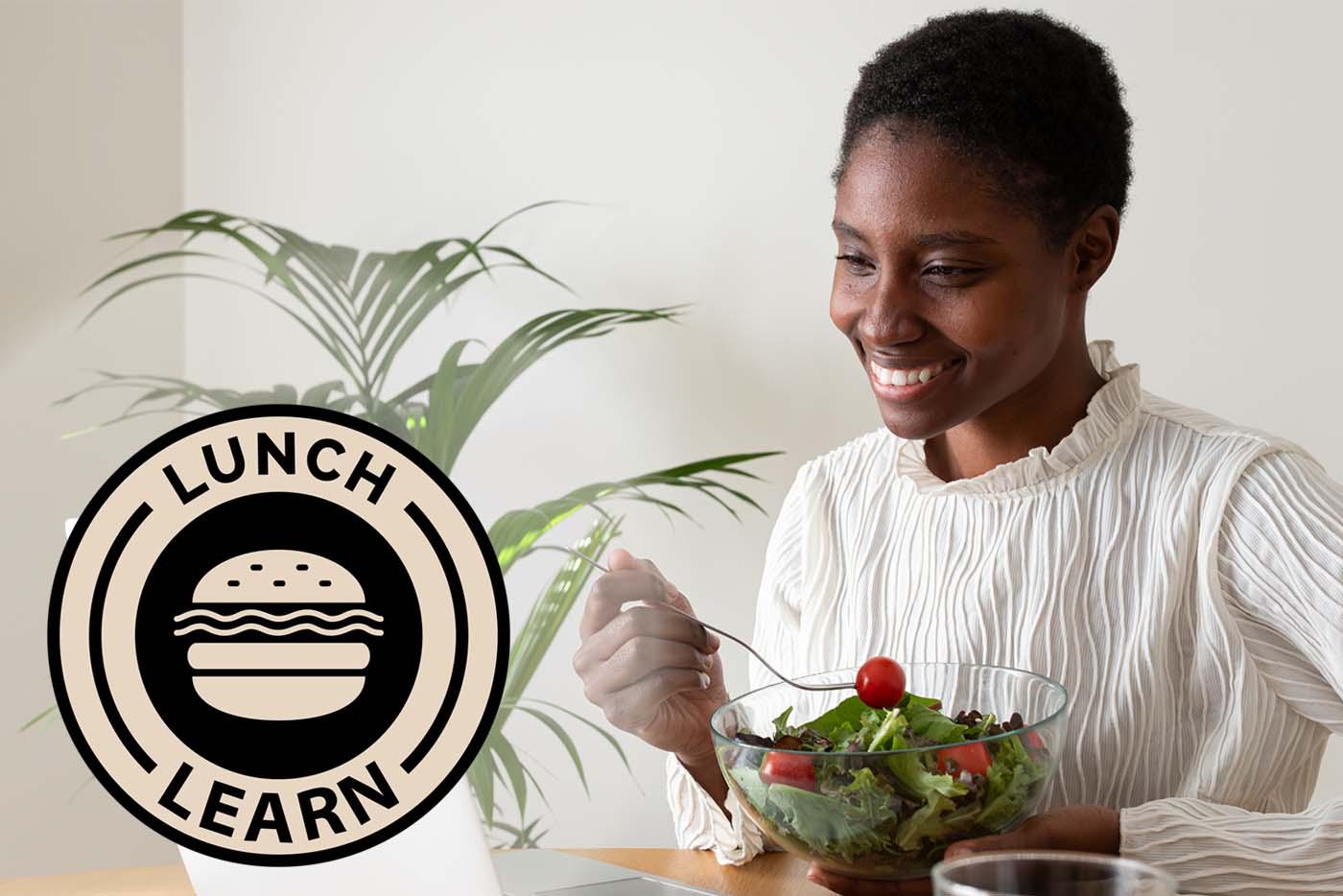 A woman eats a salad and smiles while attending lunch and learn on her laptop.