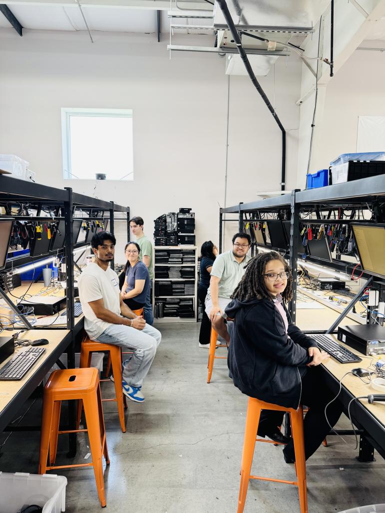 Interns are seated at work stations refurbishing computers