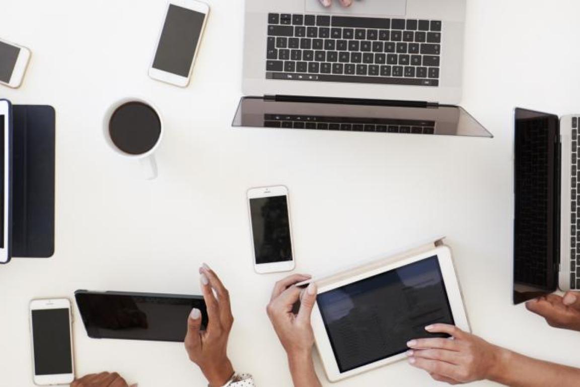 Tablets, smartphones, and laptops on a conference room table