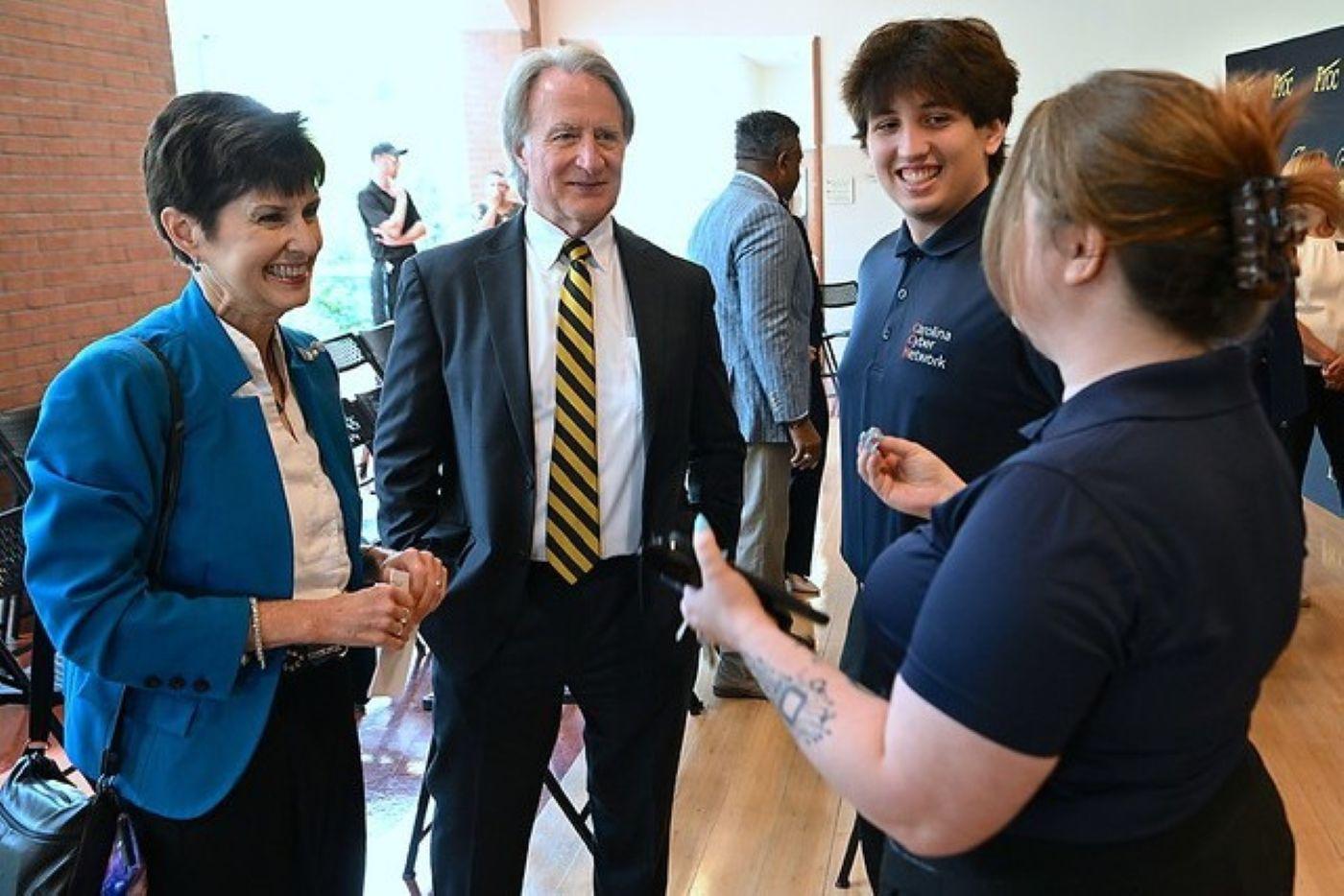 Secretary Teena Piccione and Dr. Mark Sorrells talking with two Carolina Cyber Network members.