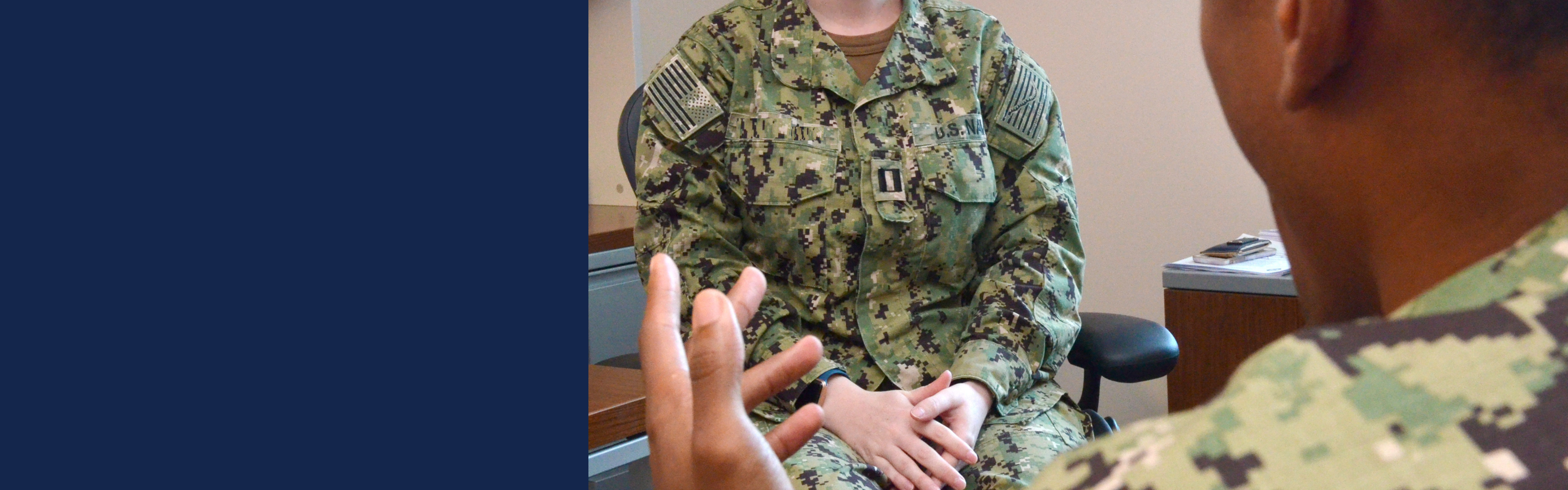 An active‑duty service member in uniform is participating in a consultation session with a specialist, with both of them in uniform.