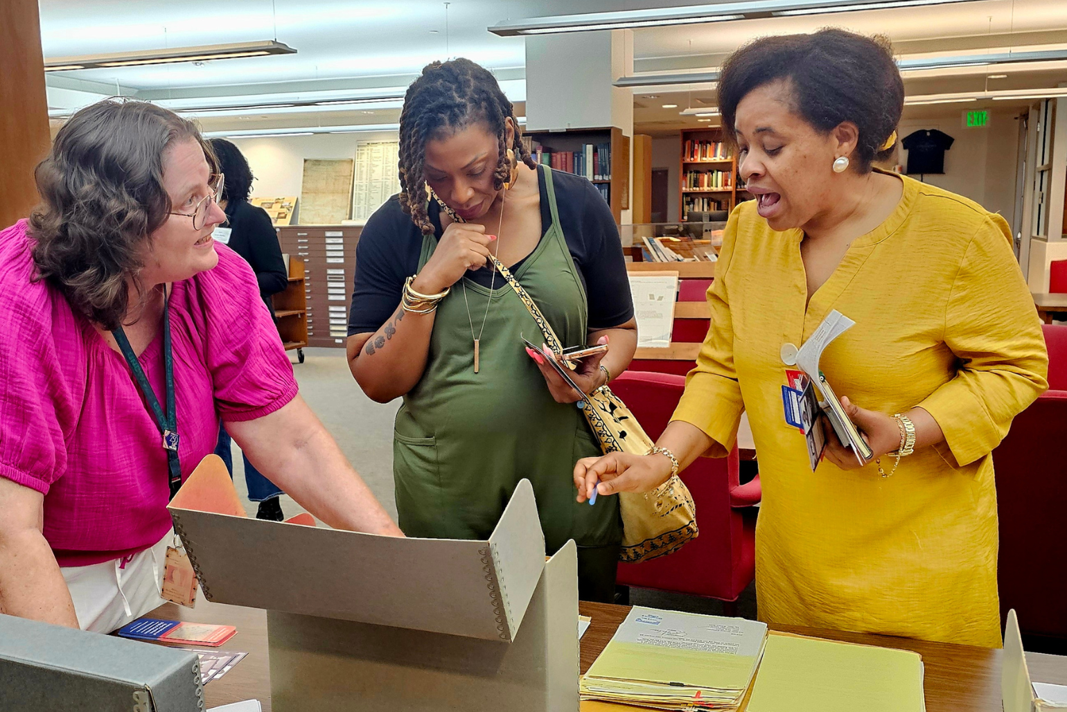 Two teachers examine documents with an archivist at the State Archives.
