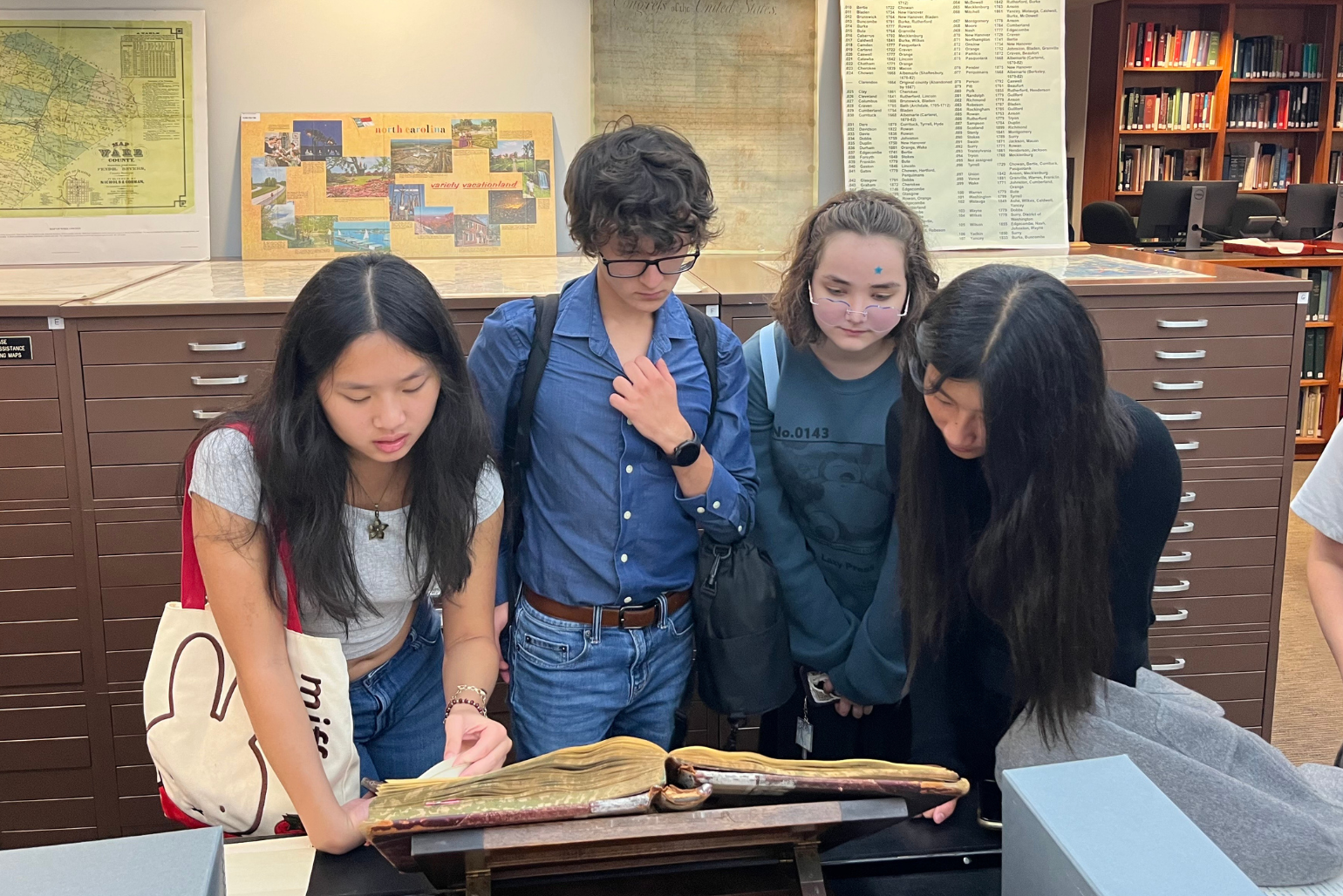 Students look at a historic book in the State Archives of NC