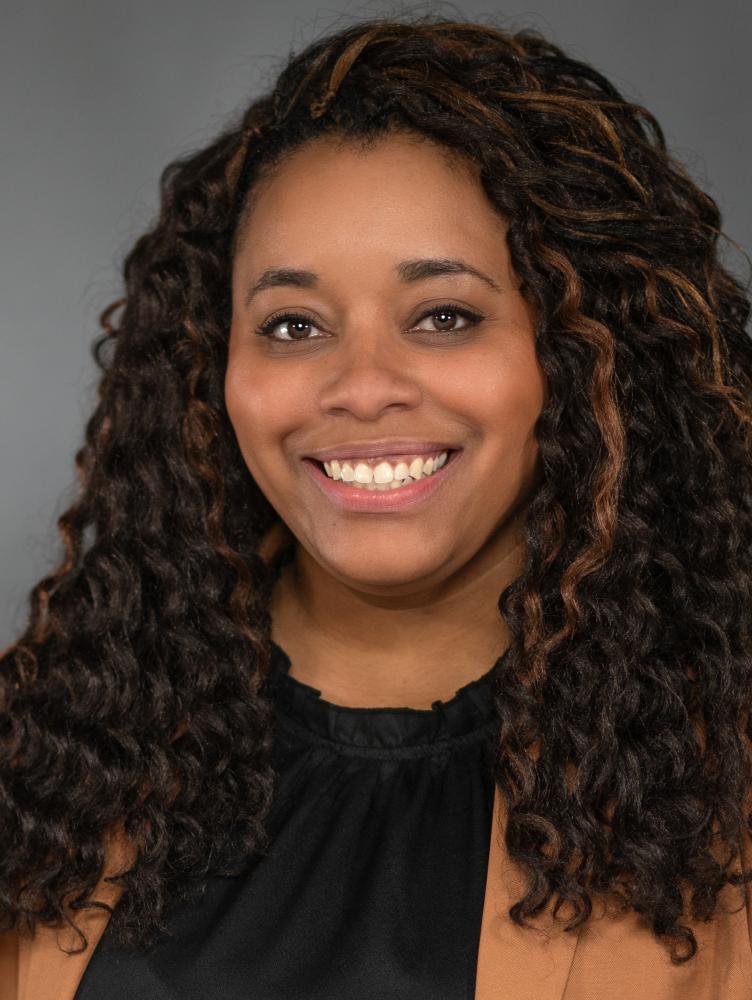 an African American woman with black hair and a brown shirt