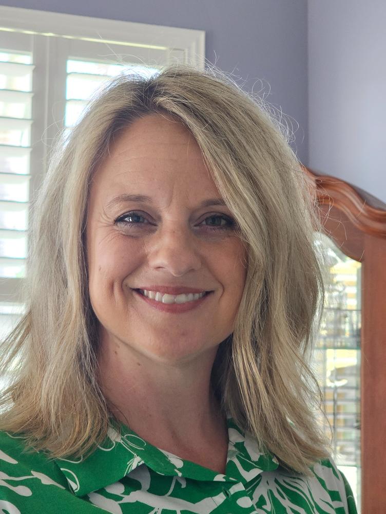 a woman with blonde hair smiles at the camera