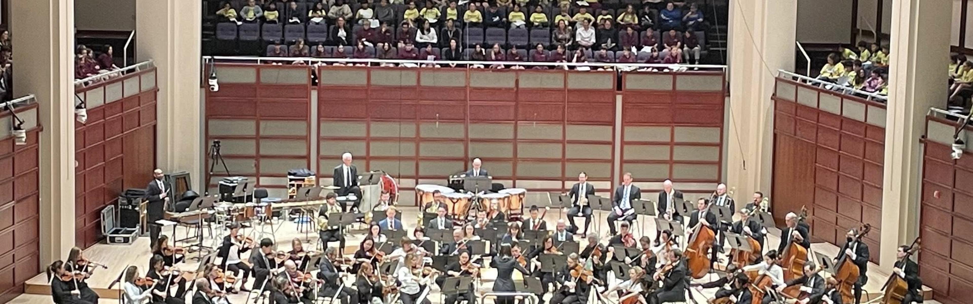 A symphony performs for students