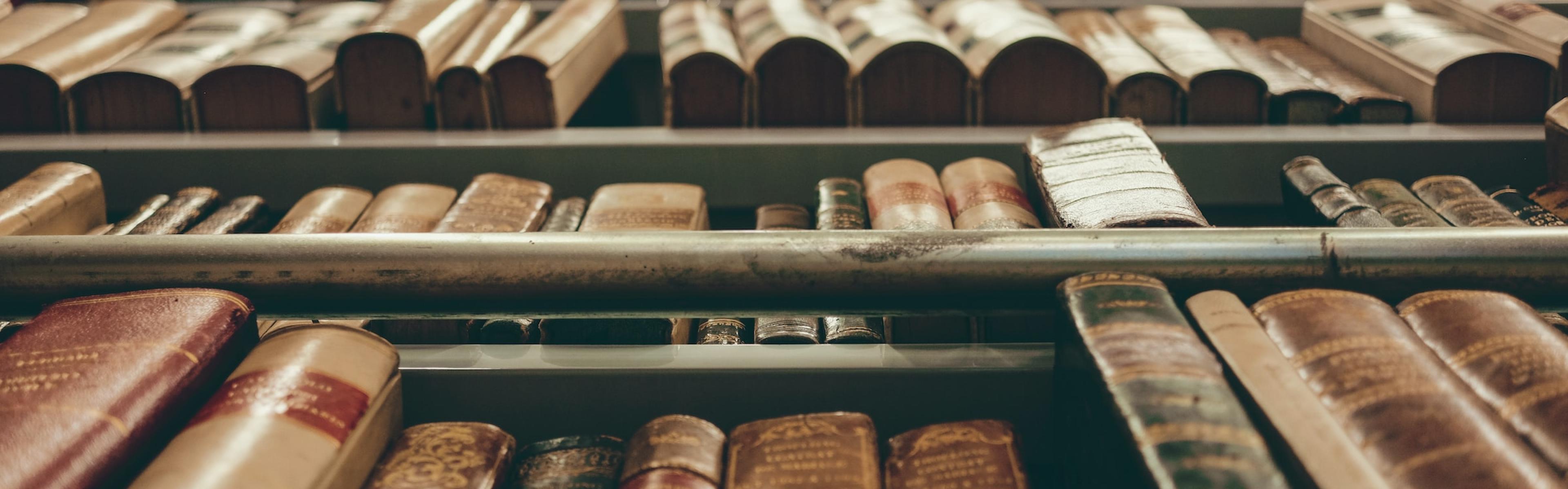 looking upwards at several shelves of antique books