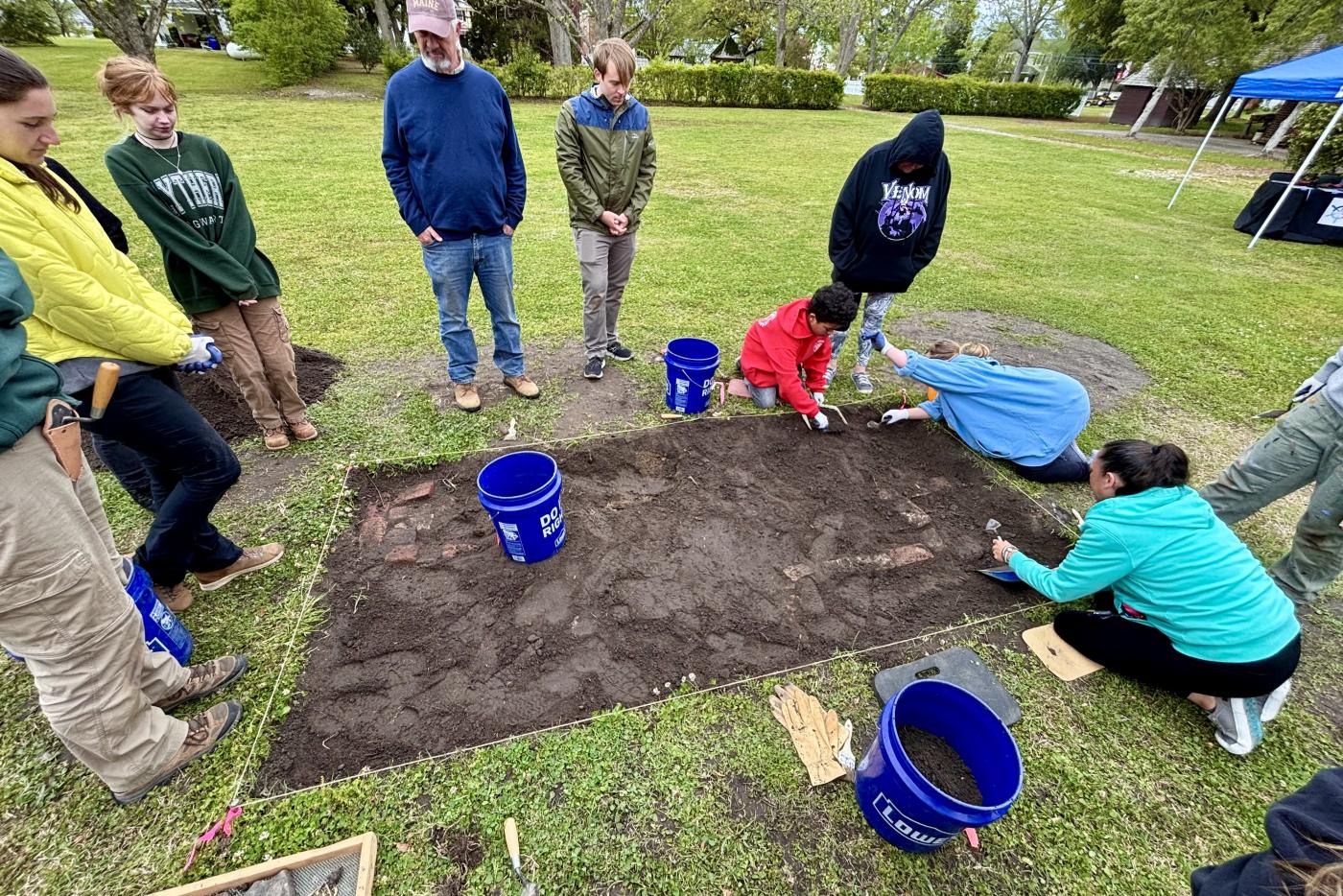a group of people watching an archaeological dig