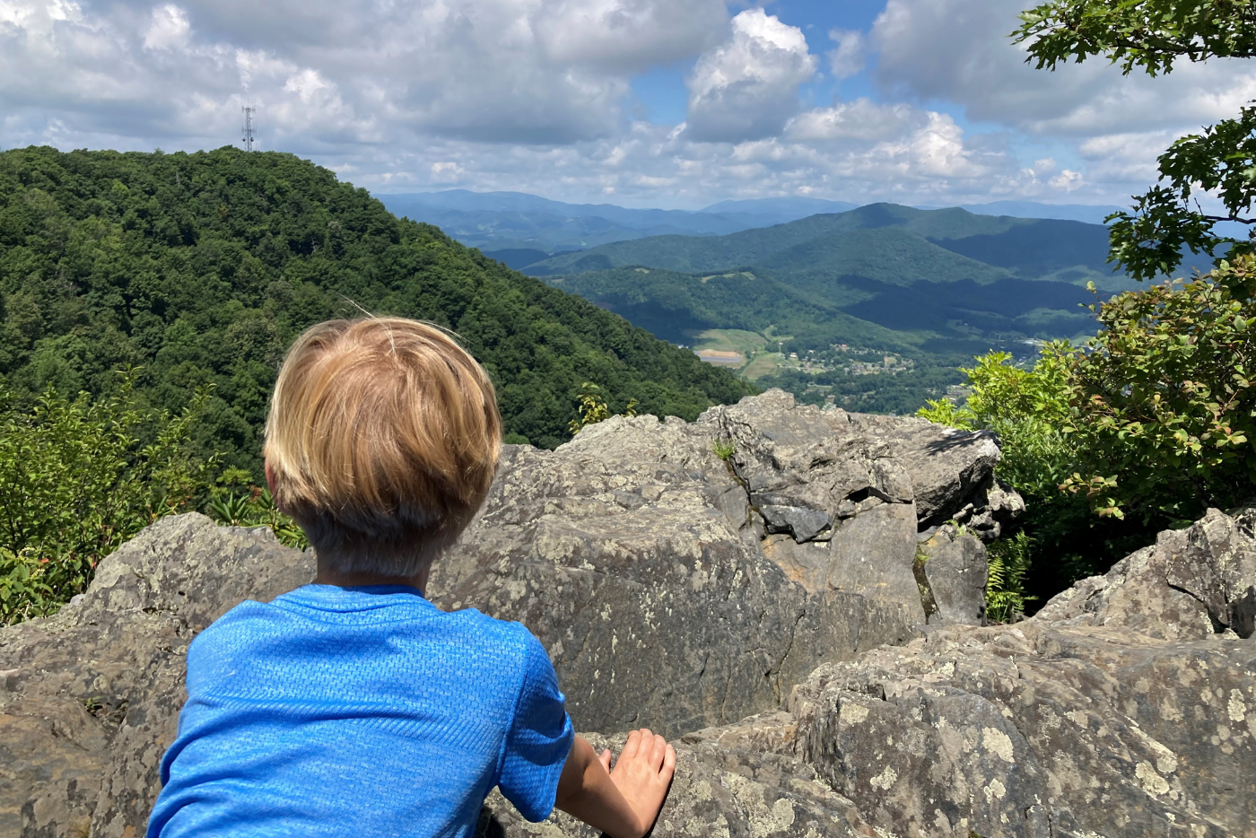 A boy looks out at a mountain view from an overlook at Mount Jefferson Recreation Area 