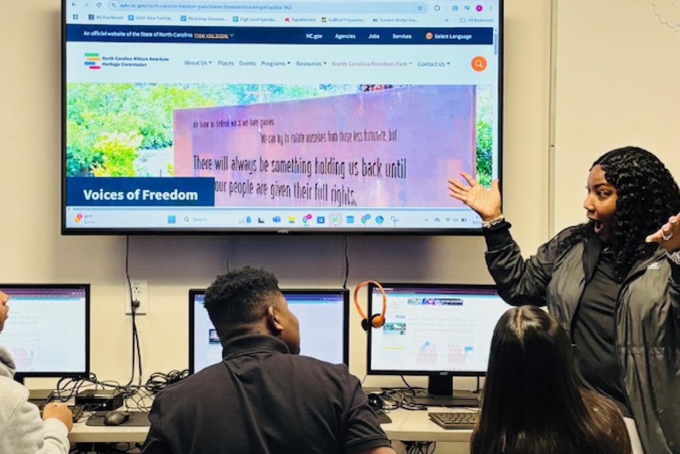 teacher pointing out screen to students