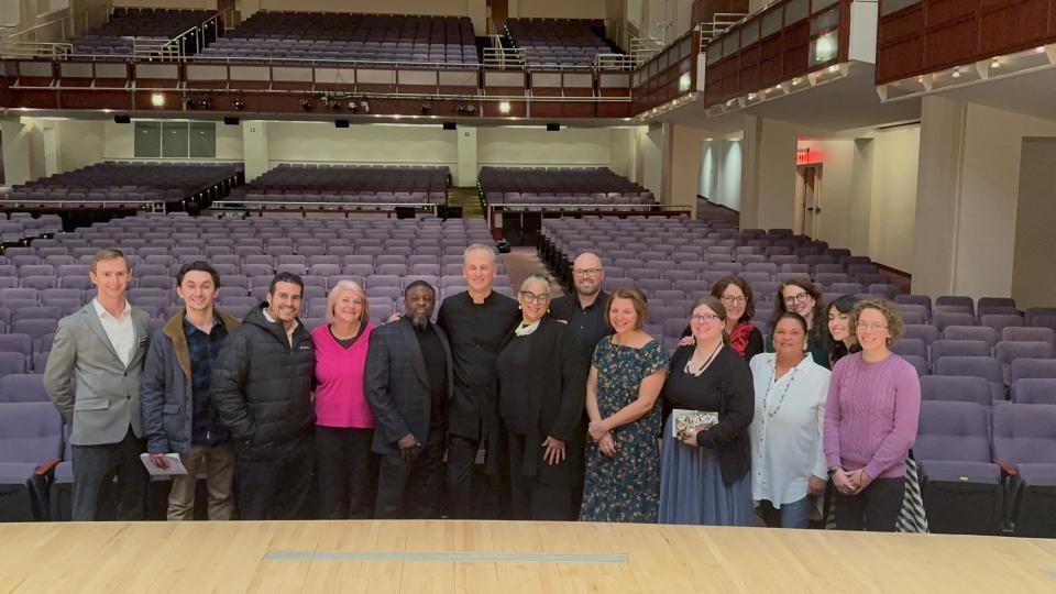 a group of teachers standing in an auditorium