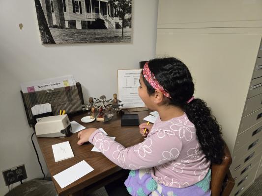 A student works at a library desk.