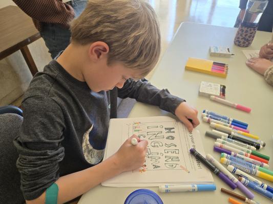 A young student works on an activity outside the State Library.