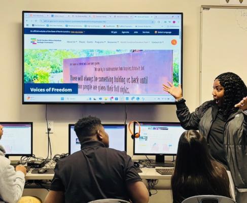teacher pointing out screen to students