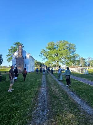 people walking along a dirt path to historical white buildings