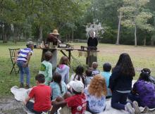 Students watch an 18th century candle making demonstration