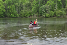 Two people canoe towards the opposite shoreline at Lake Norman State Park