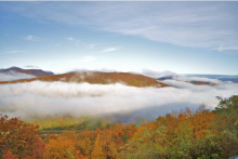 A mountain peak surrounded by fog in autumn