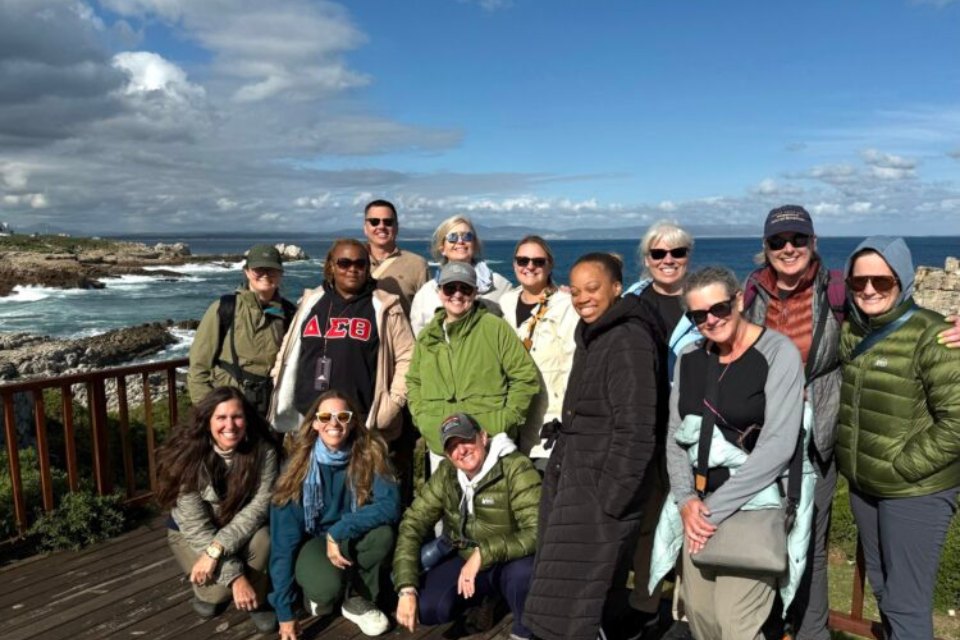 A group of teachers pose in front of the Cape of Good Hope.