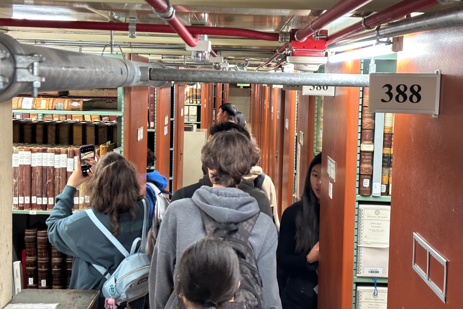 Students take pictures as they explore the stacks of the State Archives.