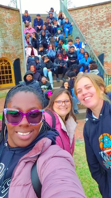 Students sit on the steps for a selfie at Fort Macon.