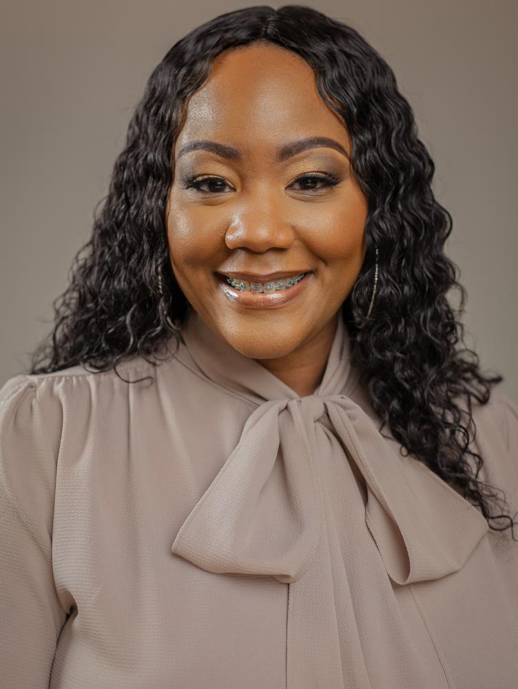 an African American woman with black hair and a brown shirt
