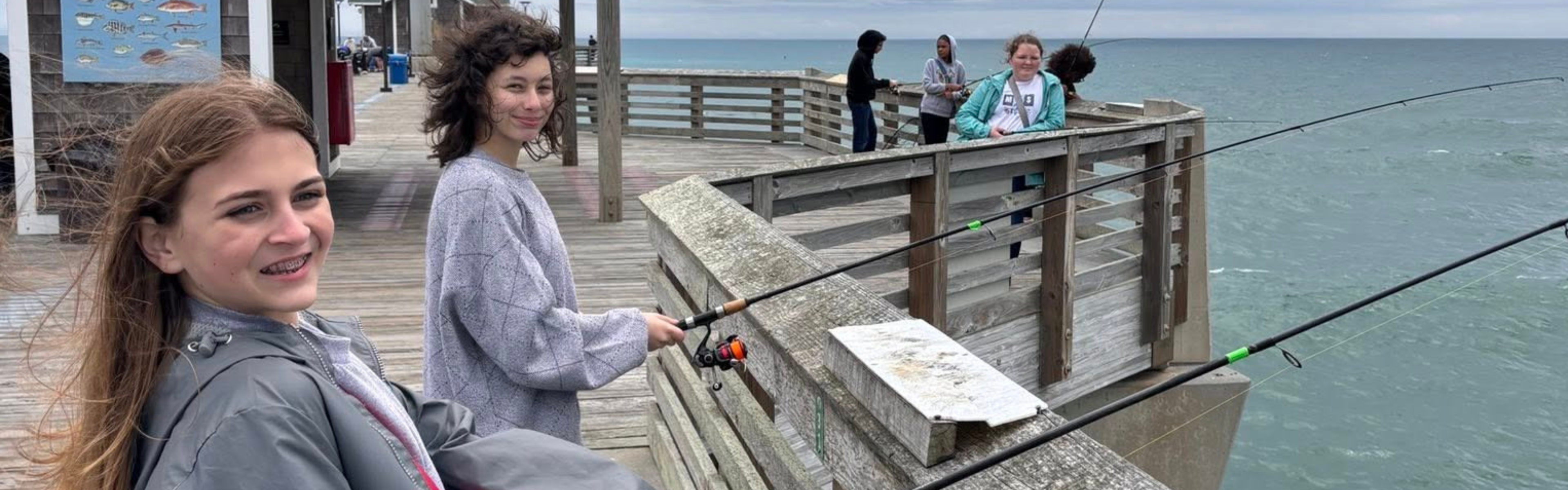Two students fish from Jennette's Pier