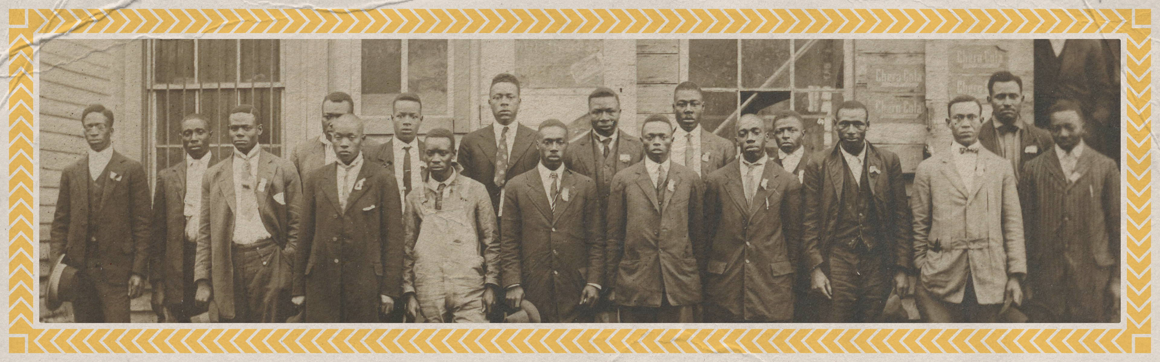 A black and white image of a group of African American men posing together dressed in formal attire