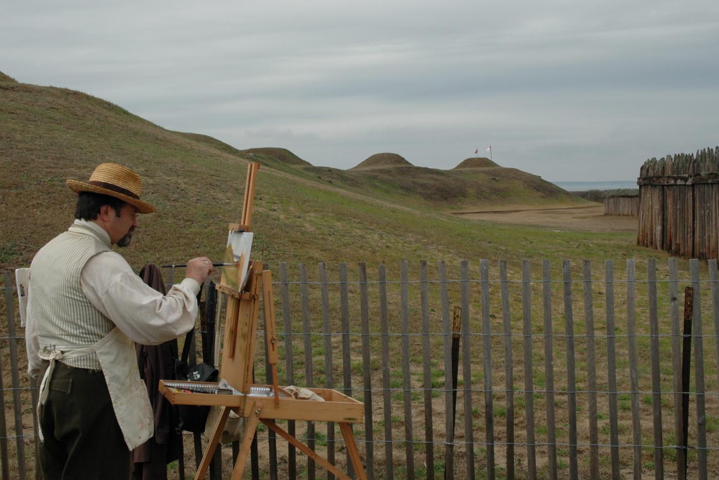 A person painting scenery from a Civil War site.