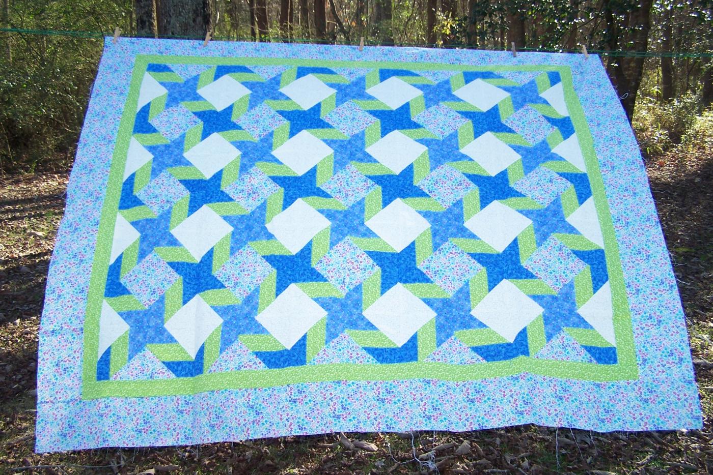 A quilt with star and diamond patterns on it.