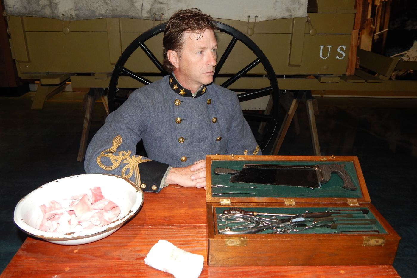 A historical interpreter in Civil War attire, displaying how BBQ was made at the time.