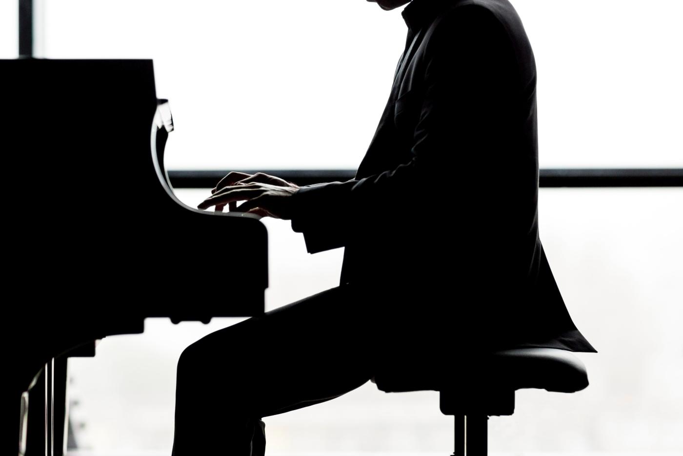 A silhouette of a pianist performing.