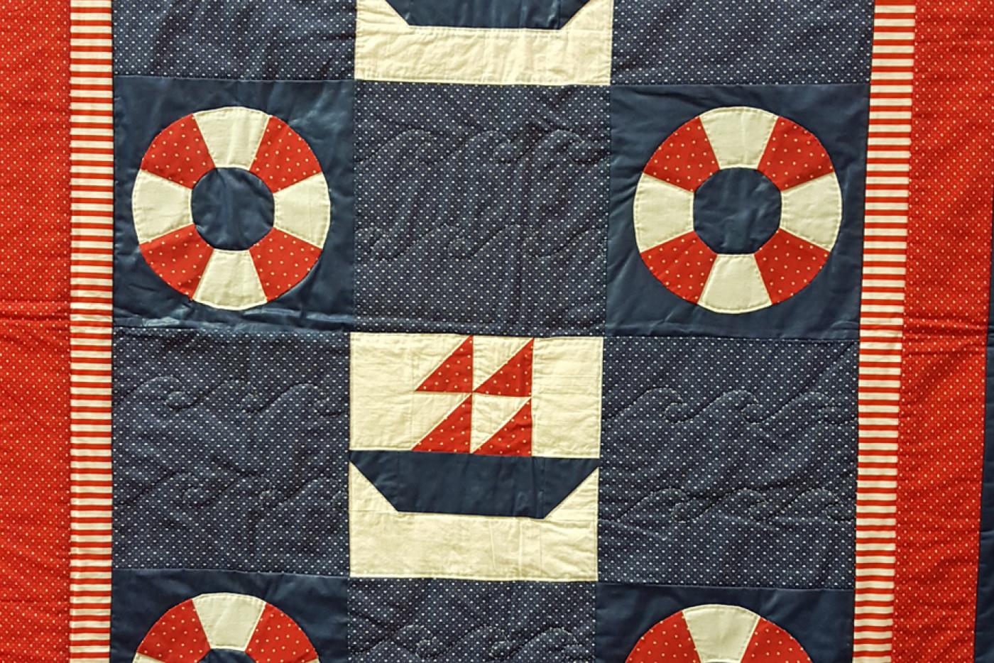 A quilt with patterns and imagery inspired by boats and life preservers.