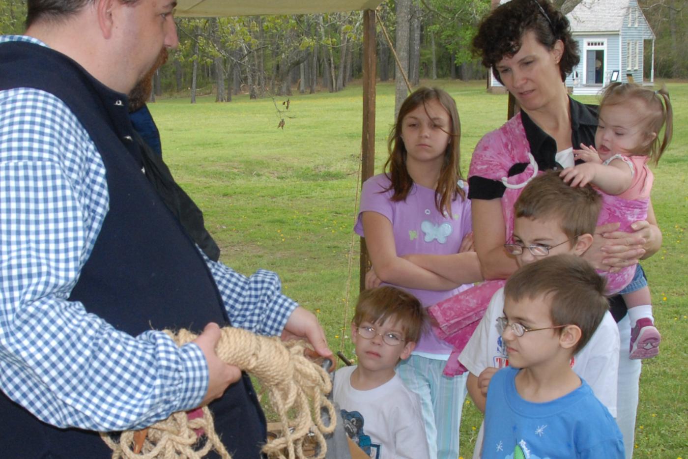 A historic interpreter speaking with a group of visitors.