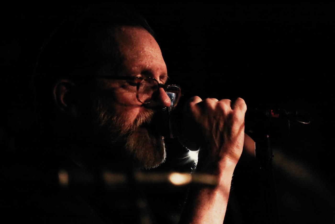 Doug MacMillan singing into a microphone.